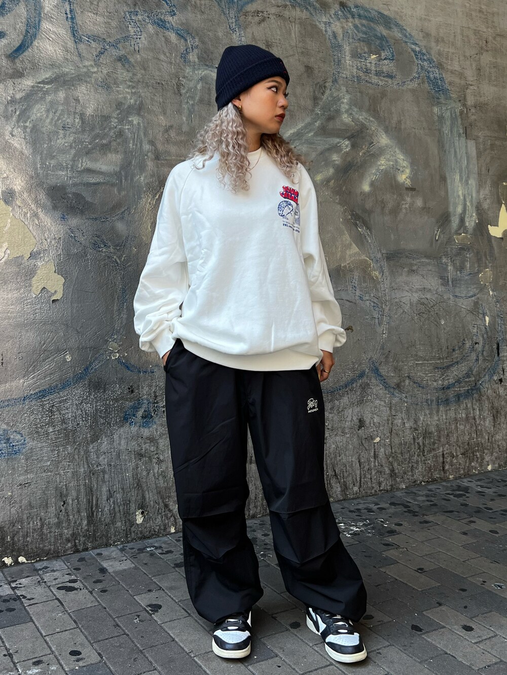 ブラック系のカーゴパンツを着用したレディースの秋コーディネートの2枚目の写真