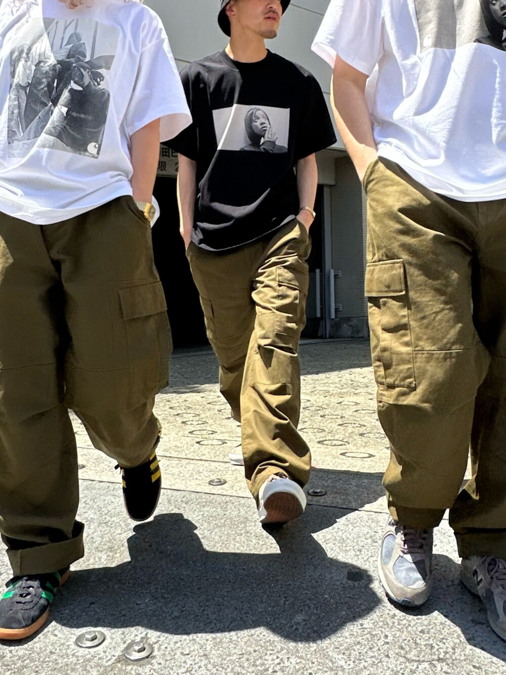 ホワイト系のTシャツ/カットソー、グリーン系のカーゴパンツ、ブラック系のスニーカーを着用したレディースの春コーディネートの5枚目の写真