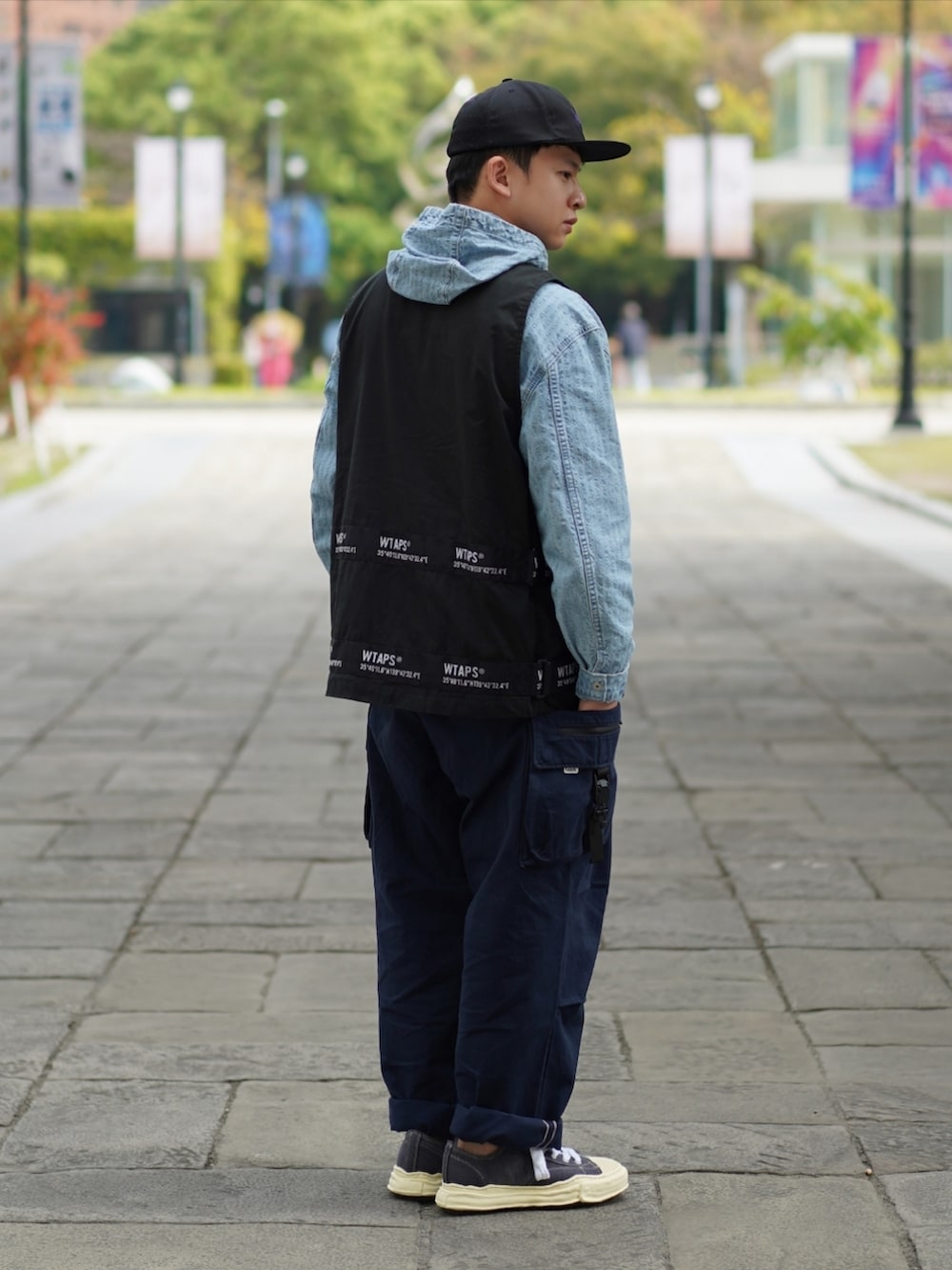 ブラック系のベスト、ブルー系のパーカー、ブルー系のチノパンツを着用したメンズの冬コーディネートの2枚目の写真