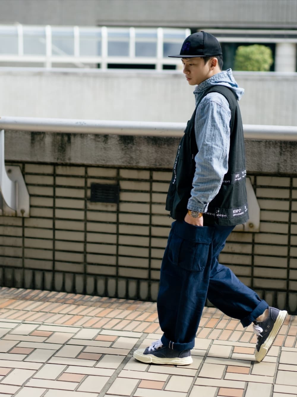 ブラック系のベスト、ブルー系のパーカー、ブルー系のチノパンツを着用したメンズの冬コーディネートの3枚目の写真