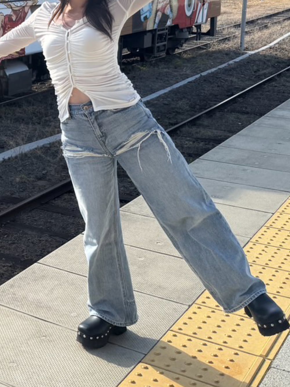 ホワイト系のTシャツ/カットソー、ブルー系のデニムパンツ、ブラック系のサンダルを着用したレディースの春コーディネートの2枚目の写真