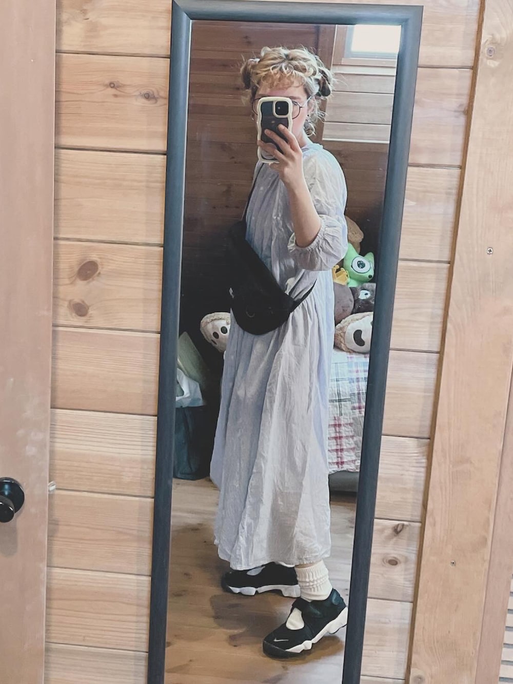 ブラック系のボディバッグ/ウエストポーチ、ブルー系のワンピース、ブラック系のサンダルを着用したレディースの春コーディネートの2枚目の写真