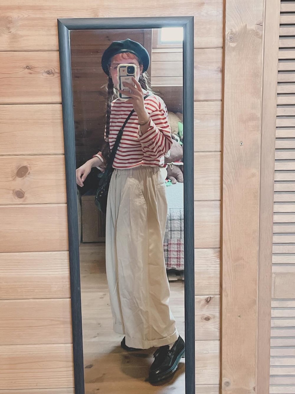 レッド系のTシャツ/カットソー、ブラック系のハンドバッグ、ブラウン系のローファーを着用したレディースの秋コーディネートの2枚目の写真