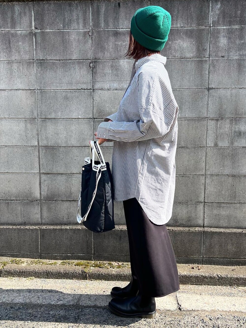 ブラック系のトートバッグ、ブラック系のブーツ、ブルー系のシャツ/ブラウスを着用したレディースの秋コーディネートの3枚目の写真