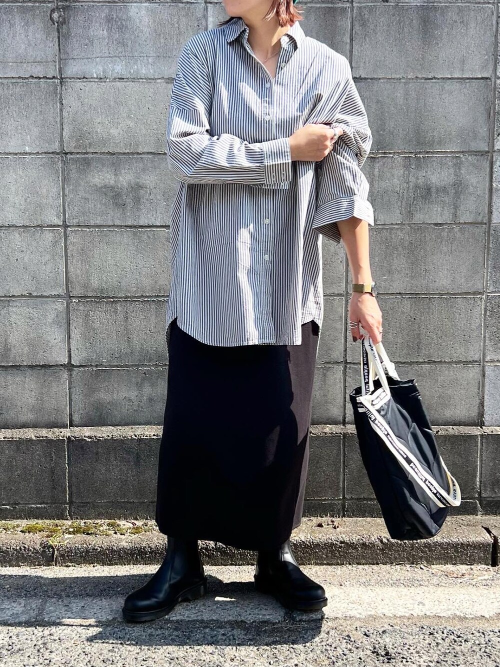 ブラック系のトートバッグ、ブラック系のブーツ、ブルー系のシャツ/ブラウスを着用したレディースの秋コーディネートの4枚目の写真