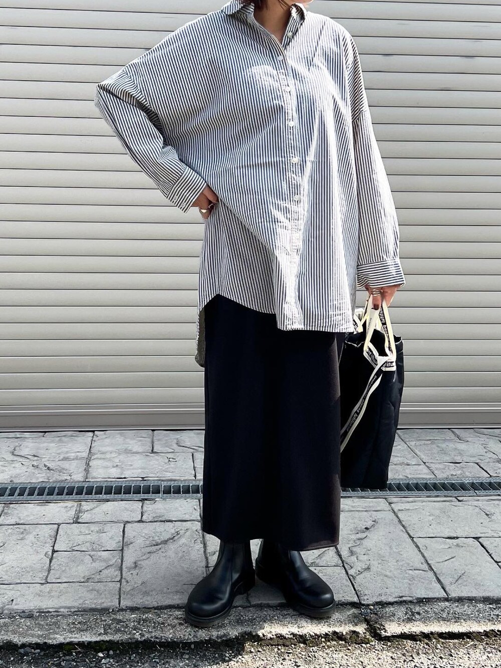 ブラック系のトートバッグ、ブラック系のブーツ、ブルー系のシャツ/ブラウスを着用したレディースの秋コーディネートの2枚目の写真