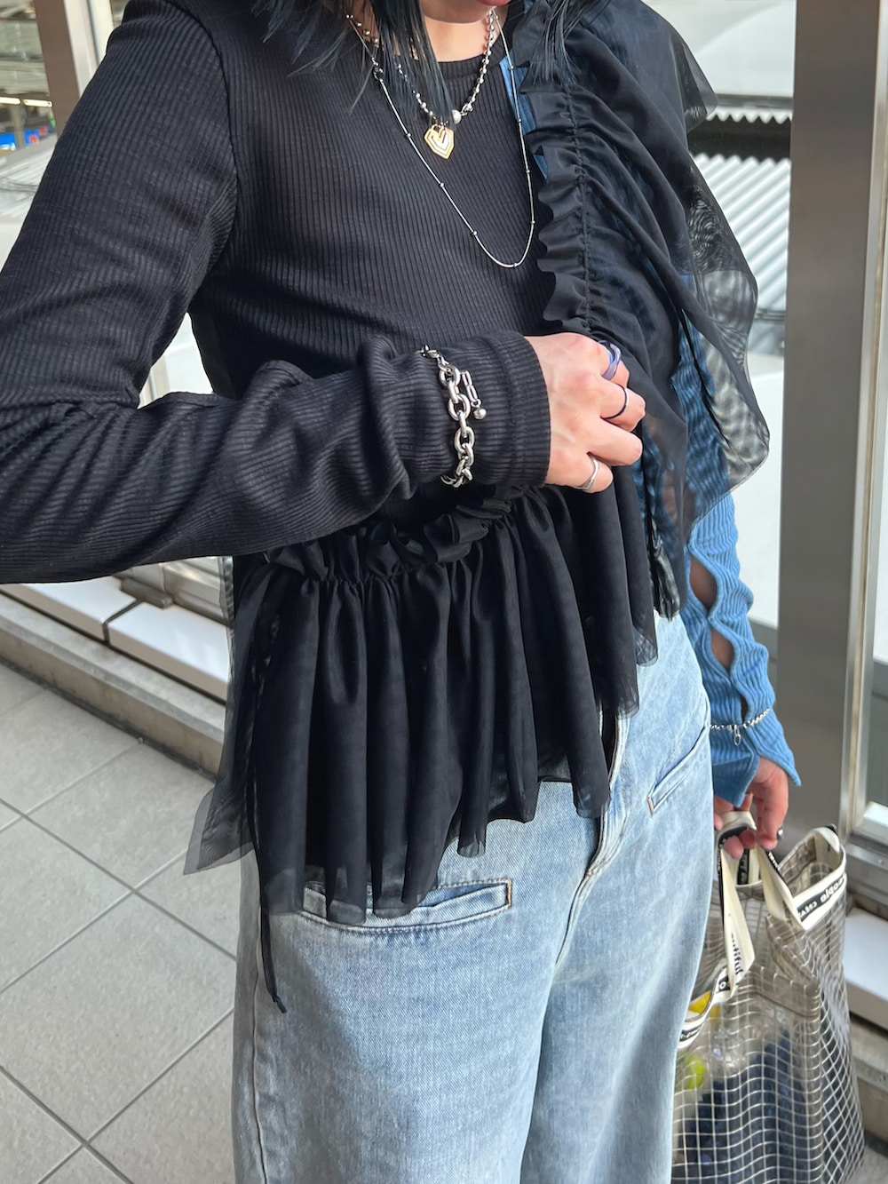 ブルー系のデニムパンツ、ブラック系のその他トップス、ブラック系のTシャツ/カットソーを着用したレディースの春コーディネートの3枚目の写真
