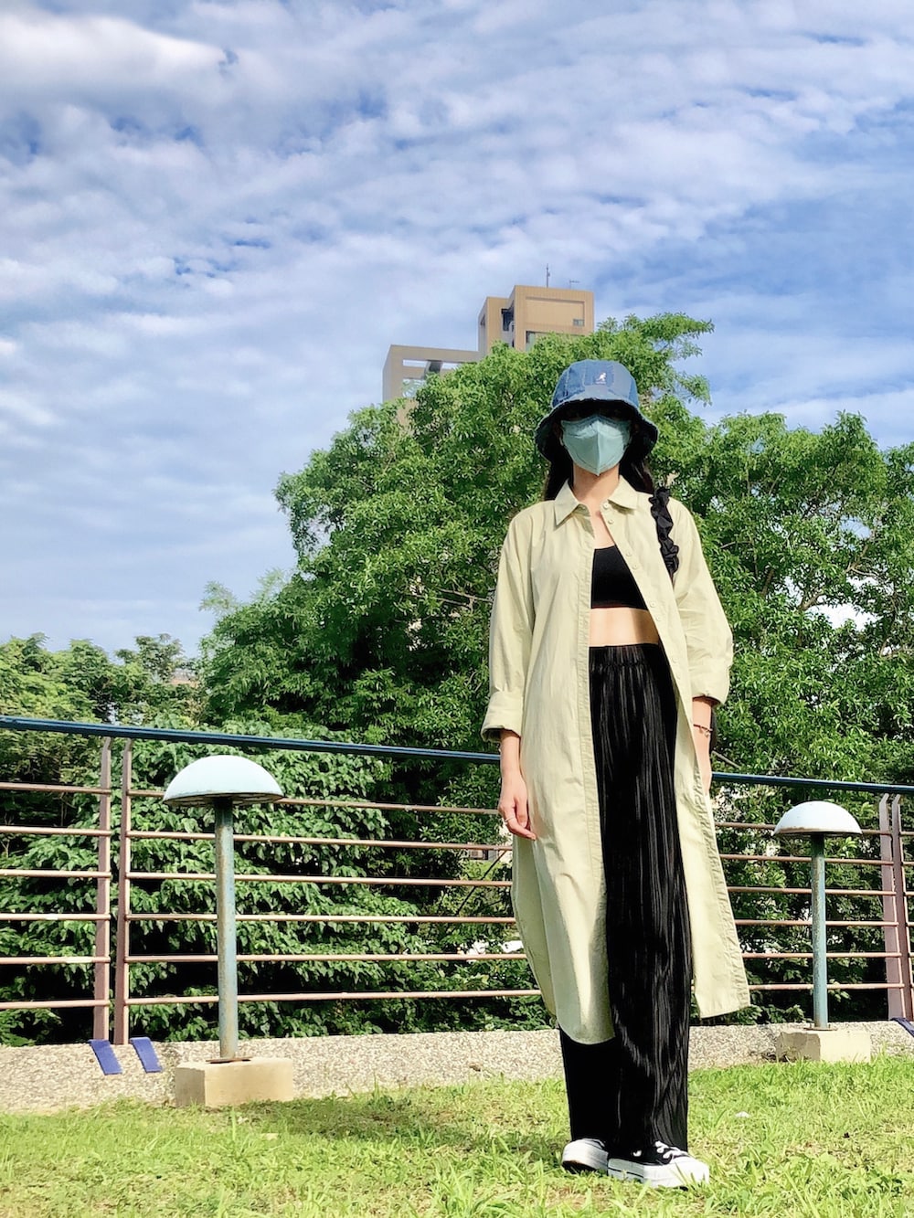 グリーン系のシャツワンピース、ブラック系のバッグ、ブラック系のパンツを着用したレディースの夏コーディネートの2枚目の写真