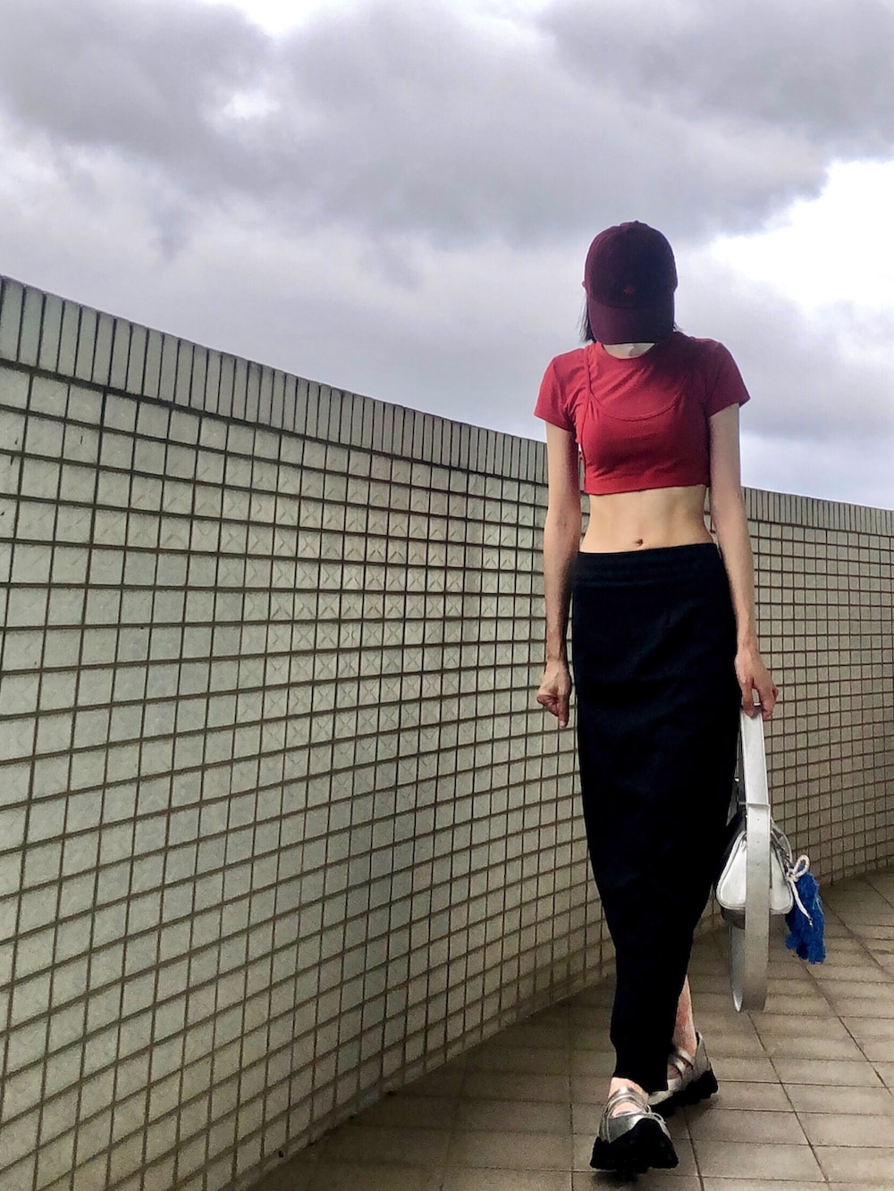 レッド系のTシャツ/カットソー、グレー系のスカート、その他のショルダーバッグを着用したレディースの秋コーディネートの2枚目の写真