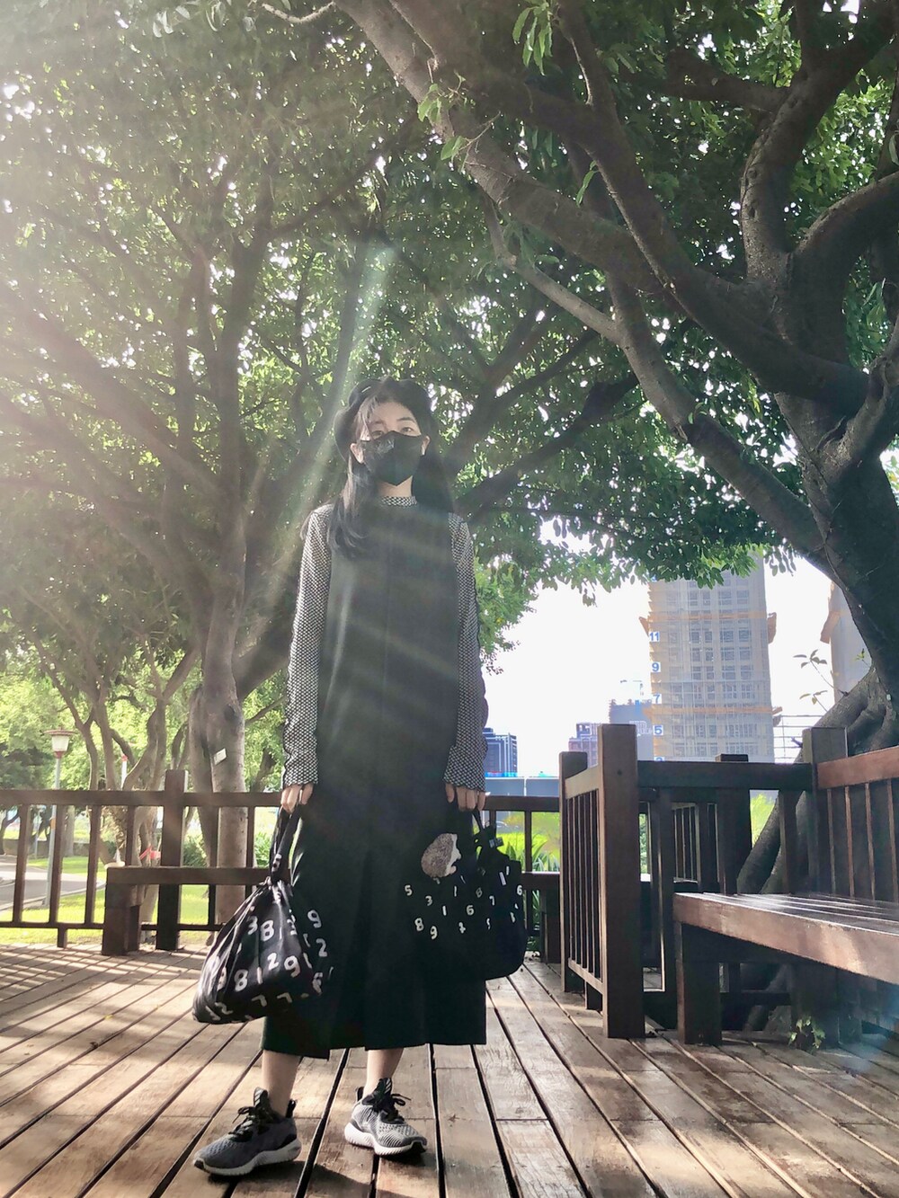 ブラック系のTシャツ/カットソー、グリーン系のジャンパースカート、ブラック系のバッグを着用したレディースの秋コーディネートの2枚目の写真