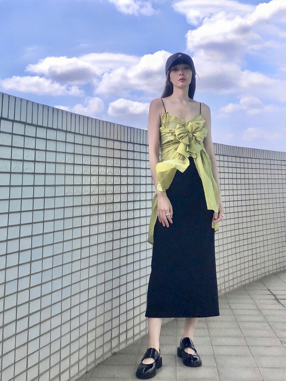 ブラック系のジャンパースカート、グリーン系のシャツ/ブラウス、シルバー系のバッグを着用したレディースの夏コーディネートの3枚目の写真