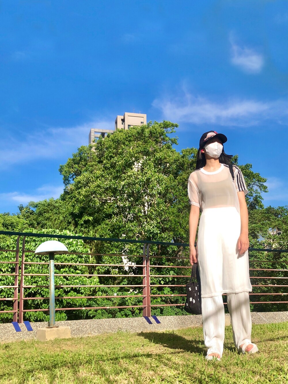 ブラック系のワンピース、ブラック系のサンダル、イエロー系のチューブトップを着用したレディースの秋コーディネートの3枚目の写真