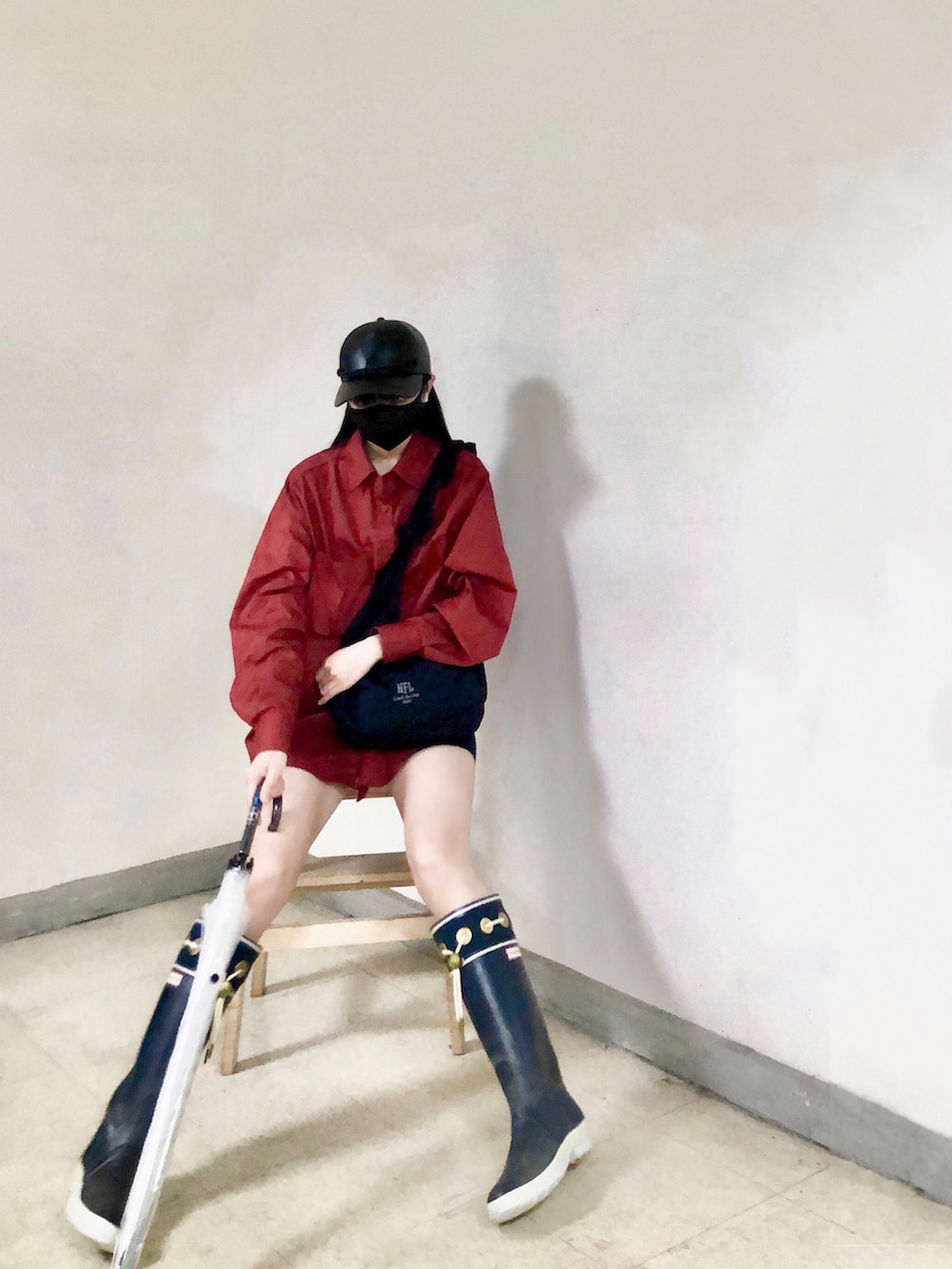 レッド系のシャツ/ブラウス、ブラック系のバッグ、ブルー系のレインシューズを着用したレディースの春コーディネートの4枚目の写真