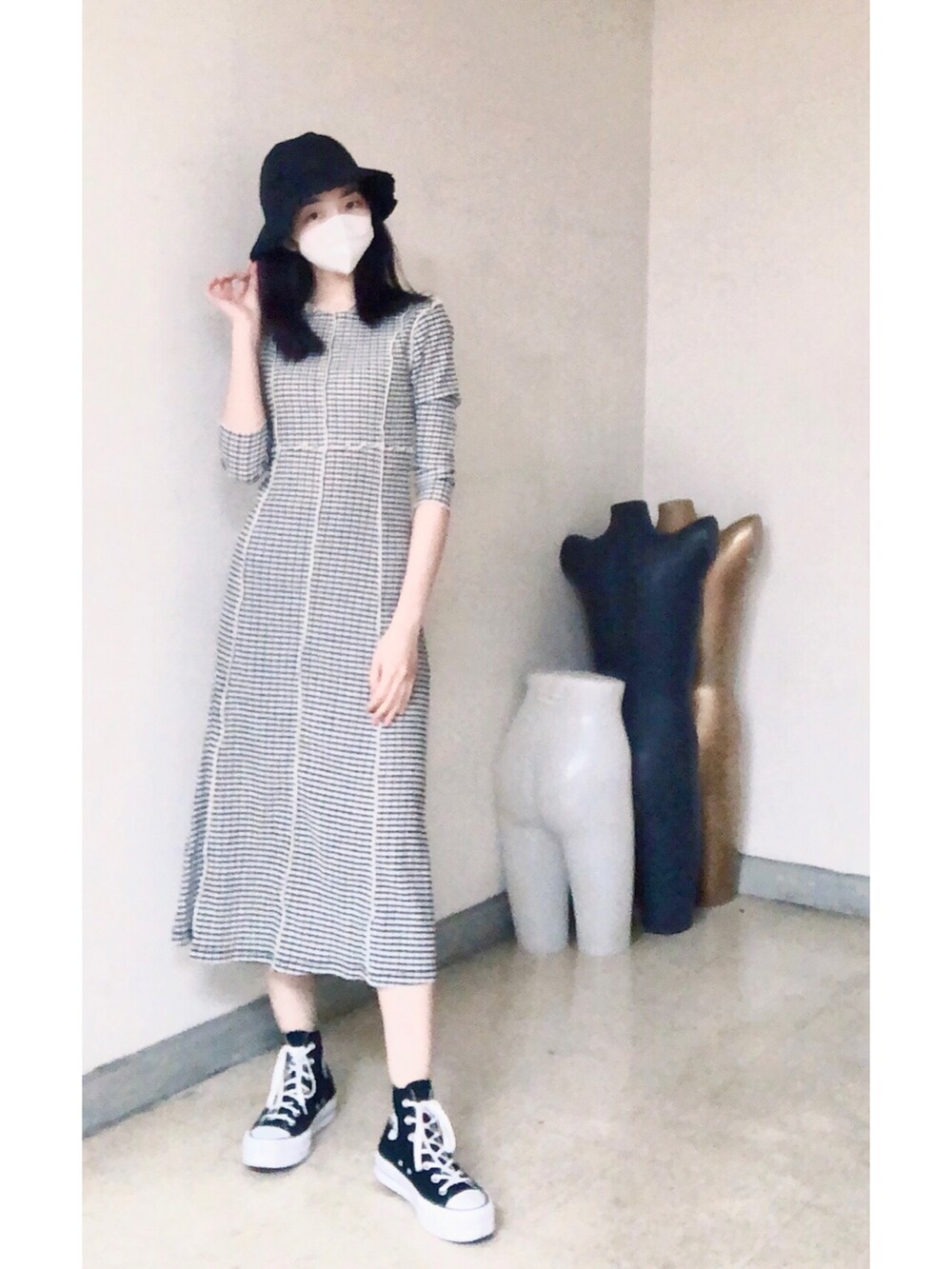 ブラック系のワンピース、ブラック系のシューズ、ブラック系のキャップを着用したレディースの春コーディネートの2枚目の写真