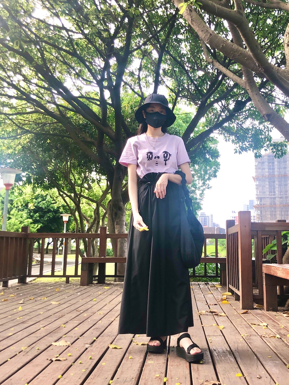 パープル系のTシャツ/カットソー、ブラック系のスカート、ブラック系のバッグを着用したレディースの夏コーディネートの2枚目の写真