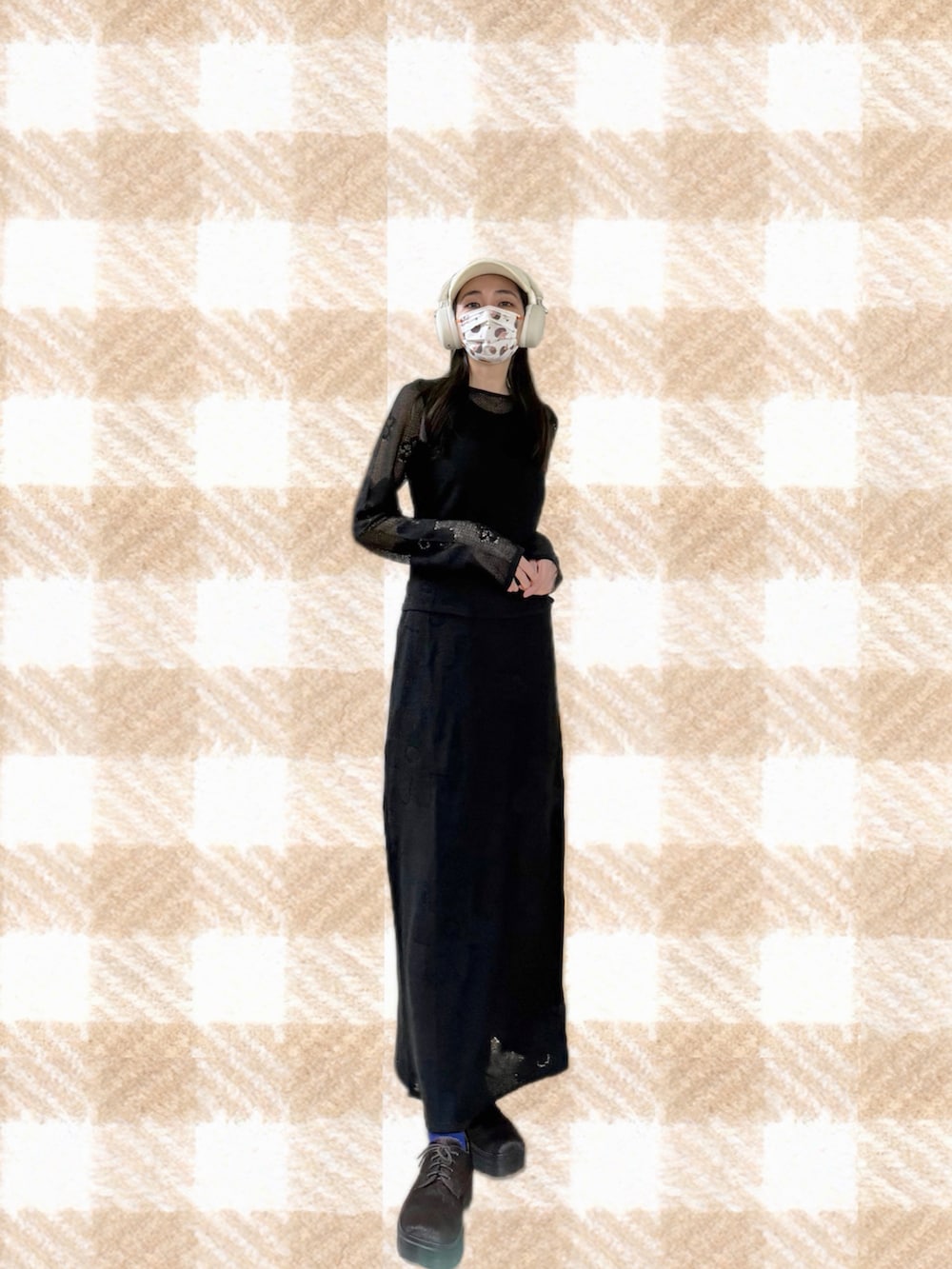 ブラック系のニット/セーター、ブラック系のスカート、ブラック系のジャンパースカートを着用したレディースの春コーディネートの3枚目の写真