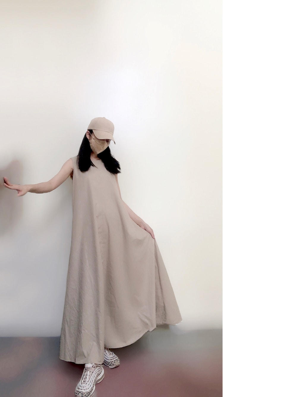 ベージュ系のワンピース、ベージュ系のスニーカー、ベージュ系の帽子を着用したレディースの夏コーディネートの2枚目の写真