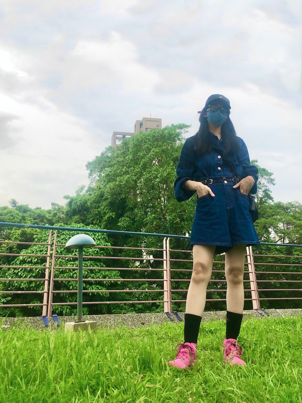 ブルー系のデニムジャケット、ブラック系のバッグ、その他のレインシューズを着用したレディースの夏コーディネートの3枚目の写真