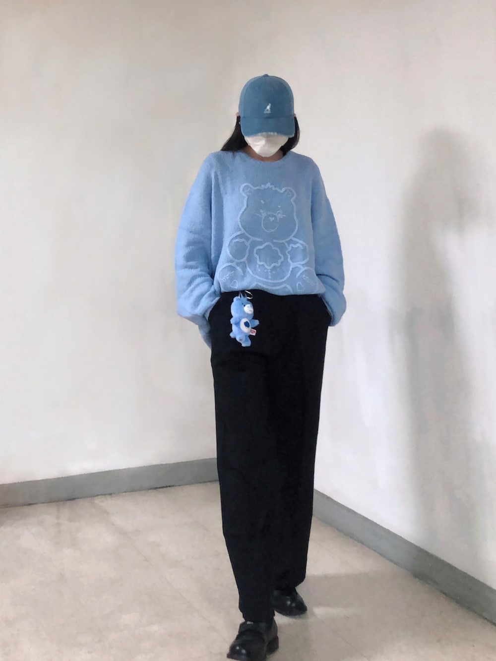 ブルー系のニット/セーター、ブラック系のスーツパンツ、グリーン系のバッグを着用したレディースの冬コーディネートの2枚目の写真