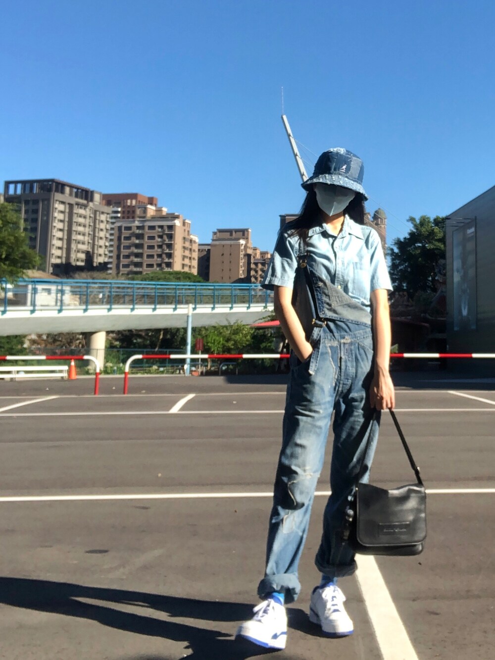 ブルー系のオールインワン・サロペット、ホワイト系のスニーカー、ブルー系のシャツ/ブラウスを着用したレディースの夏コーディネートの2枚目の写真
