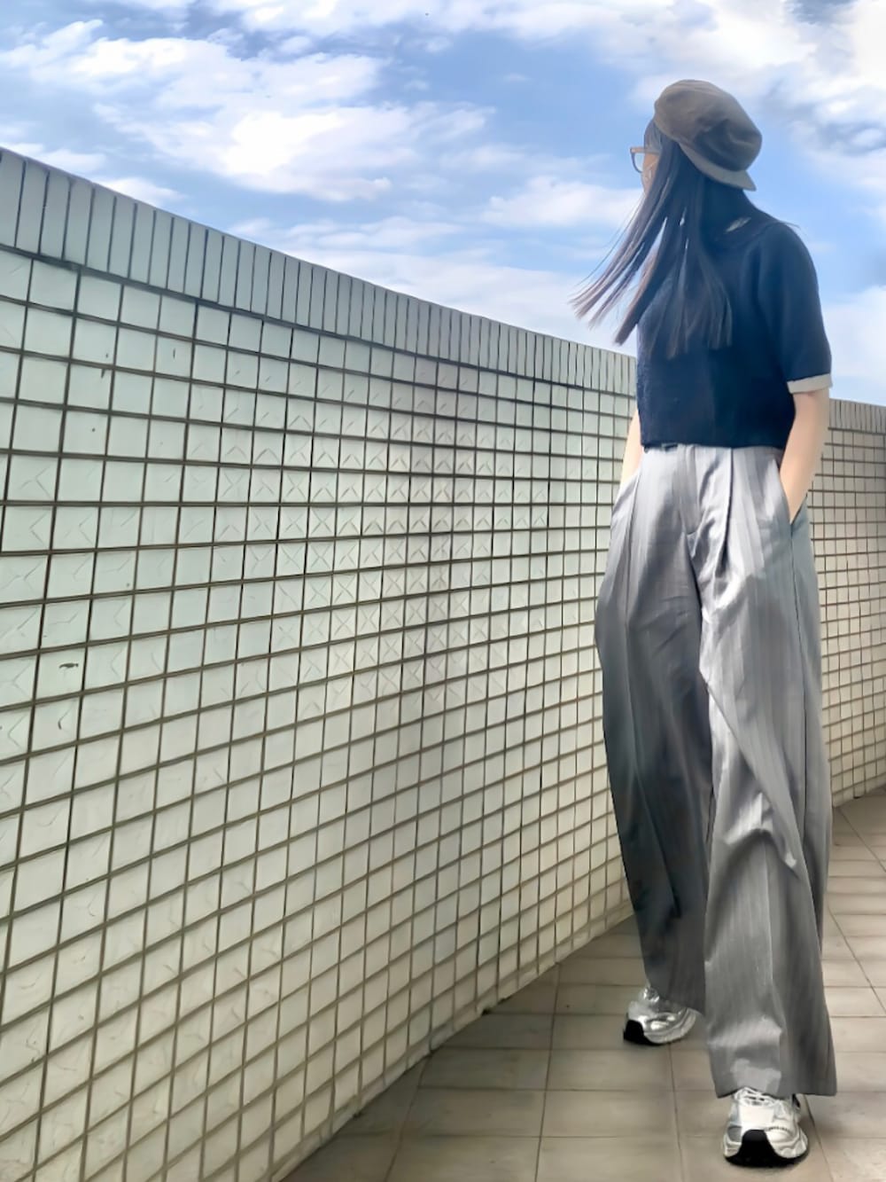 ブルー系のニット/セーター、グレー系のスーツパンツ、シルバー系のシューズを着用したレディースの冬コーディネートの2枚目の写真