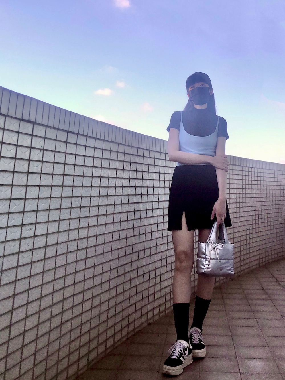 ブラック系のスニーカー、ブルー系のキャミソール、ブラック系のスカートを着用したレディースの夏コーディネートの4枚目の写真