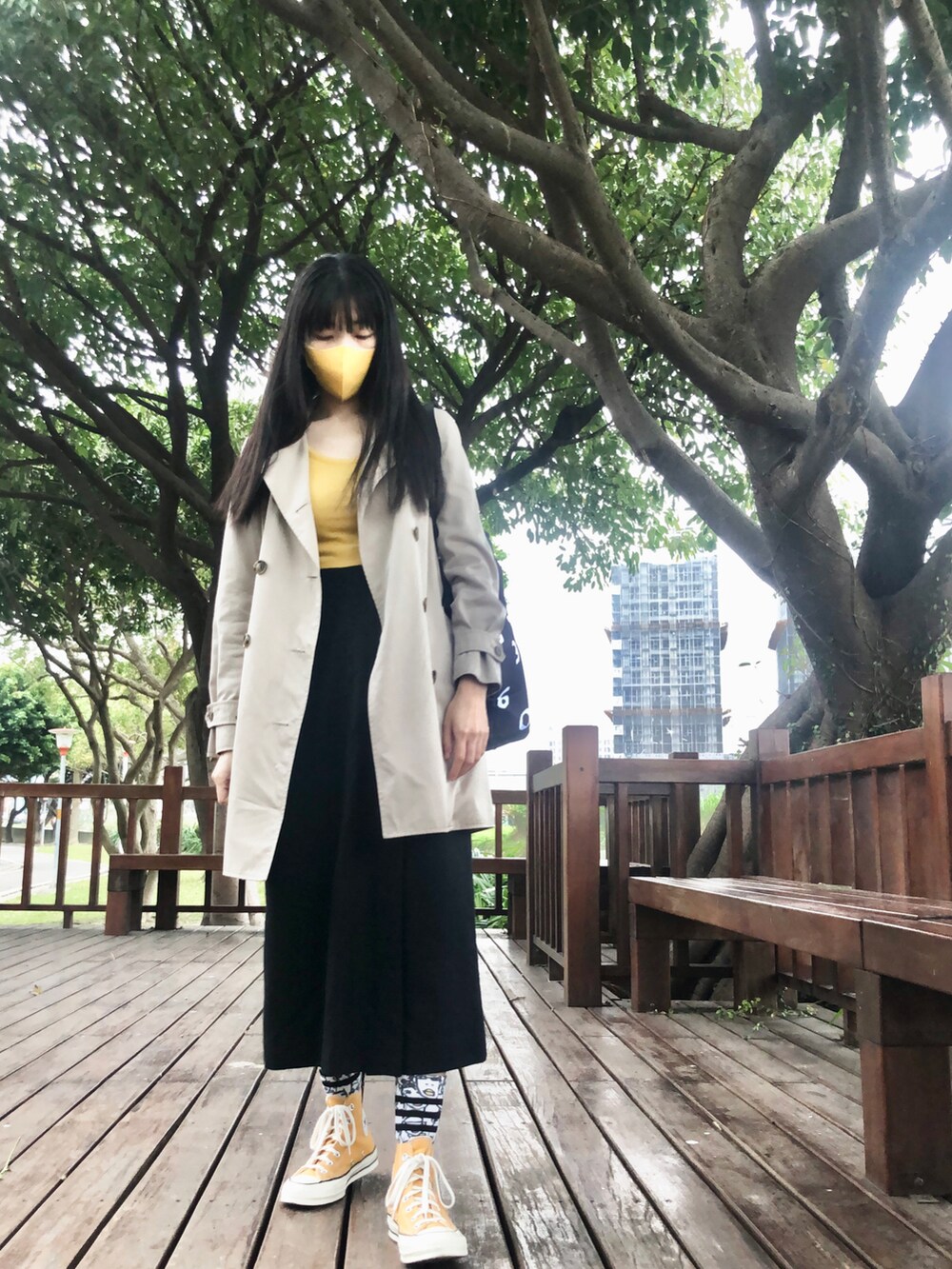 イエロー系のスニーカー、ベージュ系のその他アウター、ブラック系のキャップを着用したレディースの冬コーディネートの5枚目の写真