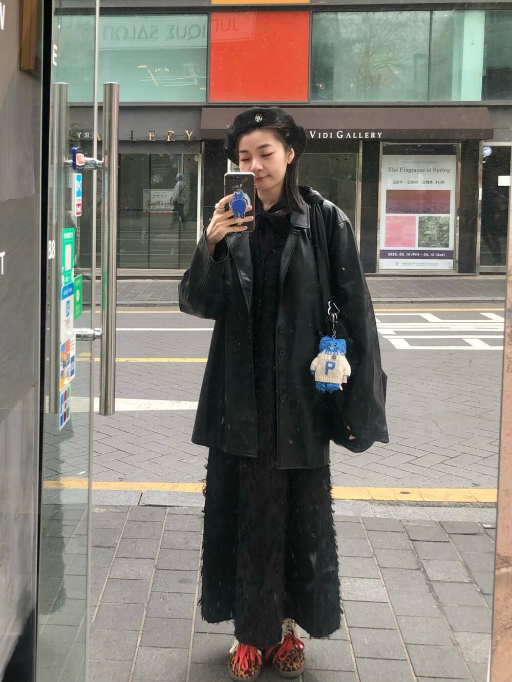 ブラック系のスーツジャケット、ブラック系のジャンパースカート、ブラック系のトップスを着用したレディースの春コーディネートの3枚目の写真