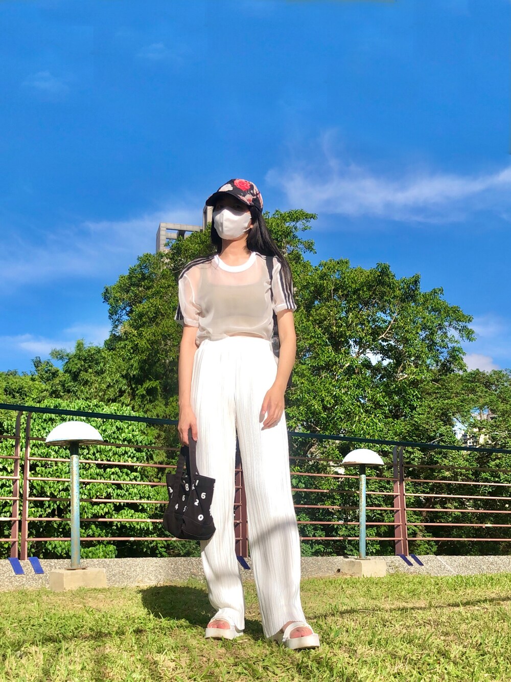 ブラック系のワンピース、ブラック系のサンダル、イエロー系のチューブトップを着用したレディースの秋コーディネートの4枚目の写真