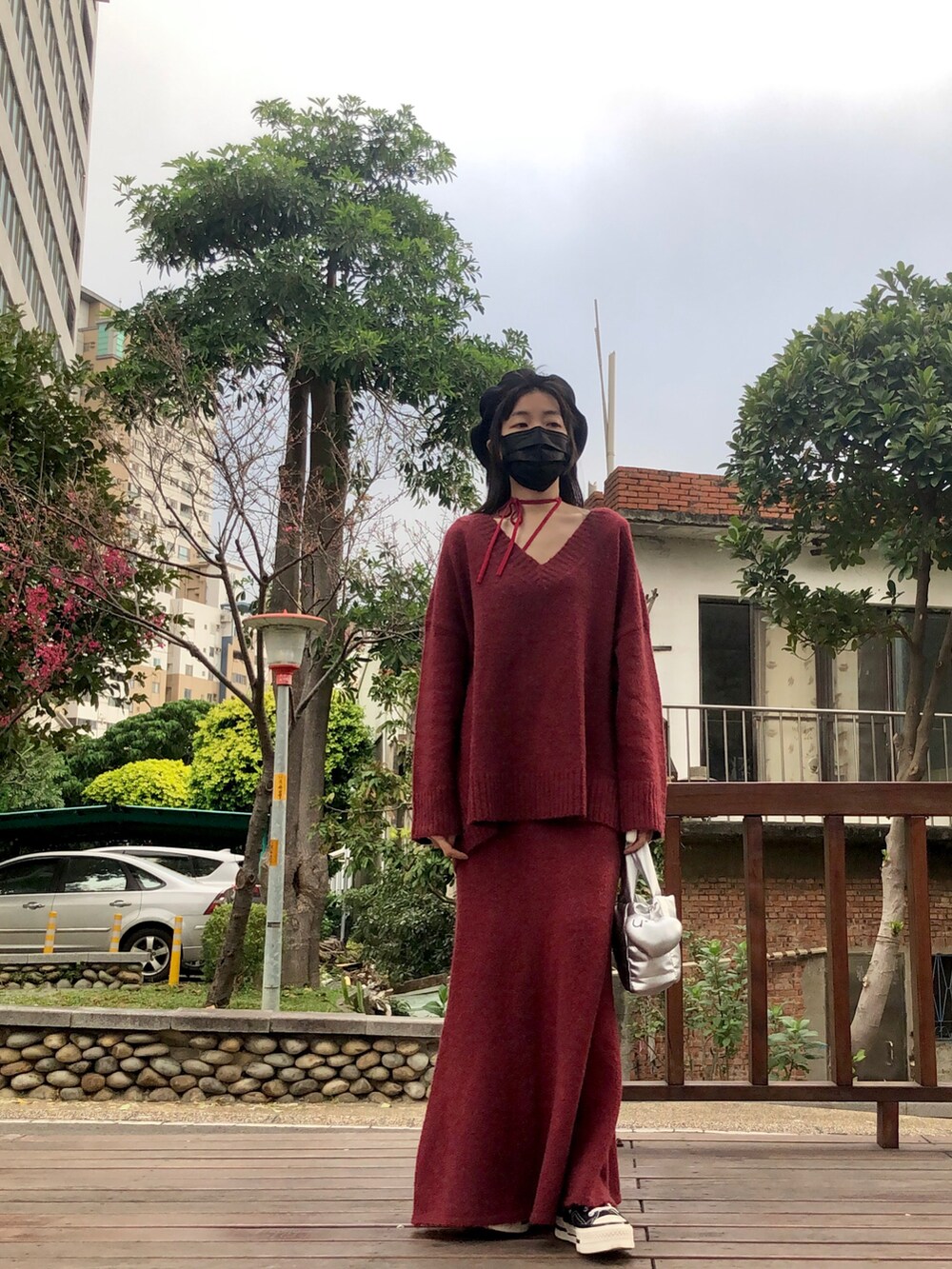 ブラック系のその他アウター、レッド系のニット/セーター、レッド系のトップスを着用したレディースの春コーディネートの3枚目の写真