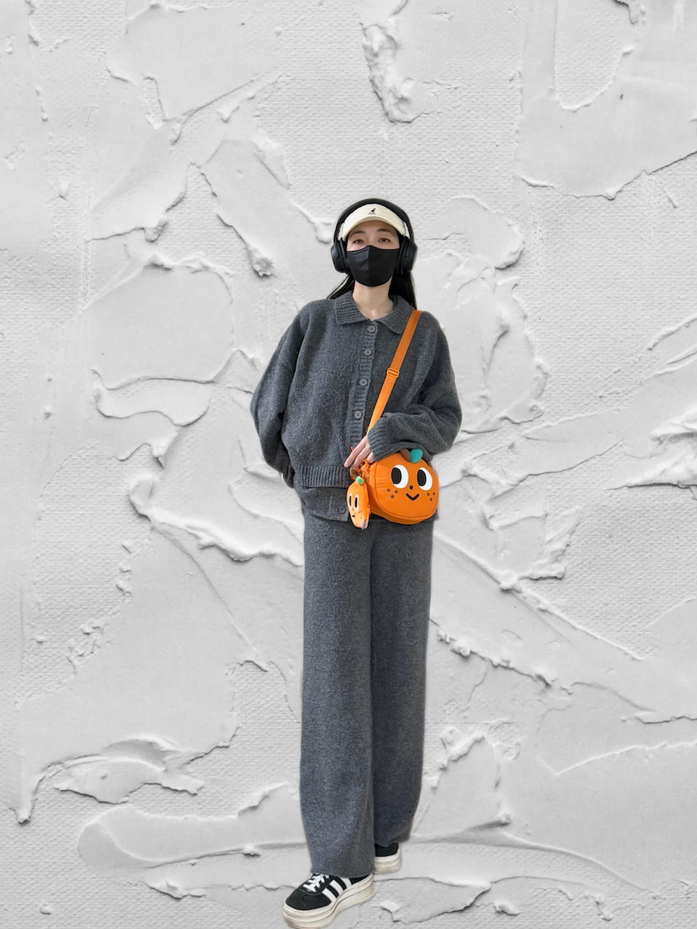 ブラック系のスニーカー、グレー系のベスト、ブラック系のノーカラージャケットを着用したレディースの冬コーディネートの2枚目の写真