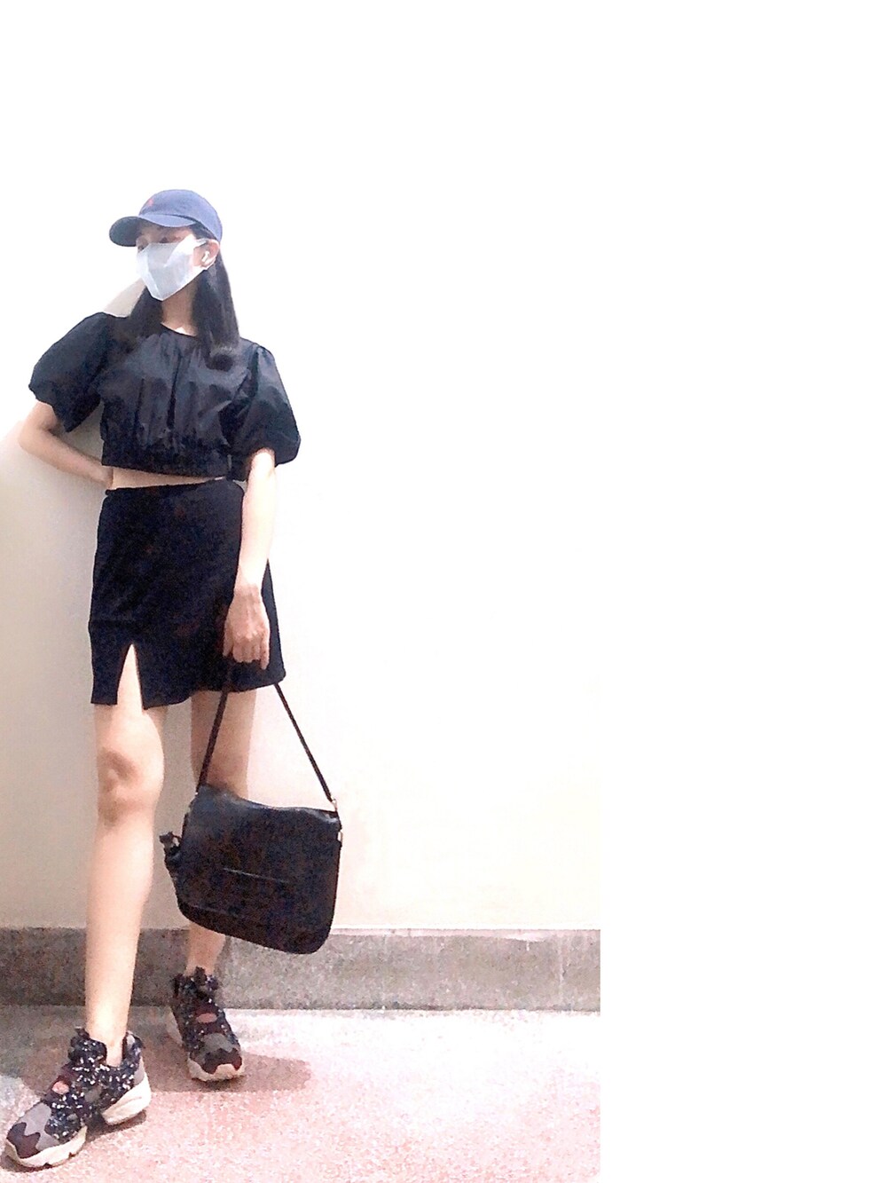 ブラック系のトップス、ブラック系のスカート、その他のスニーカーを着用したレディースの夏コーディネートの2枚目の写真