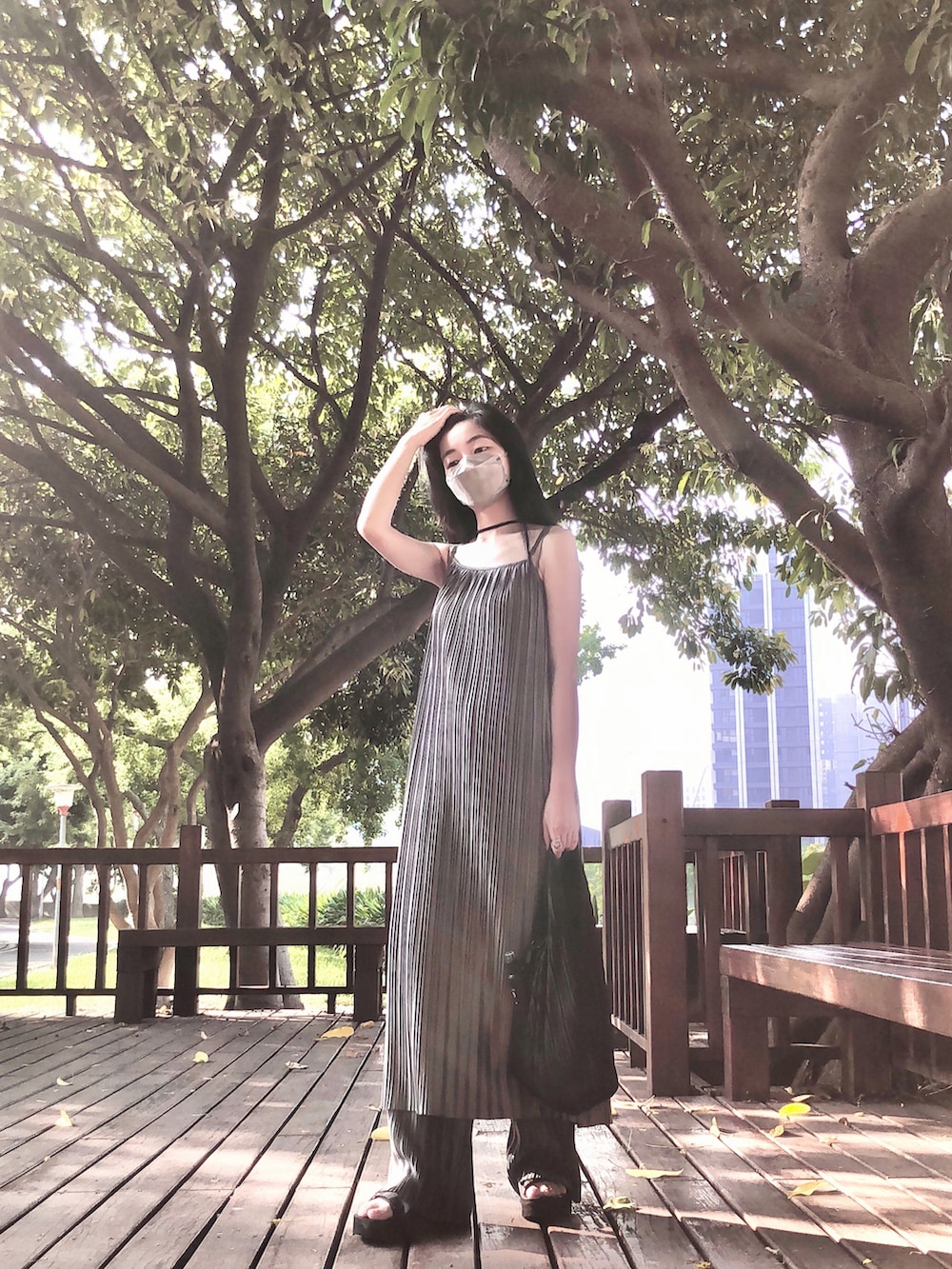 ブラック系のサンダル、グレー系のパンツ、グレー系のジャンパースカートを着用したレディースの秋コーディネートの2枚目の写真