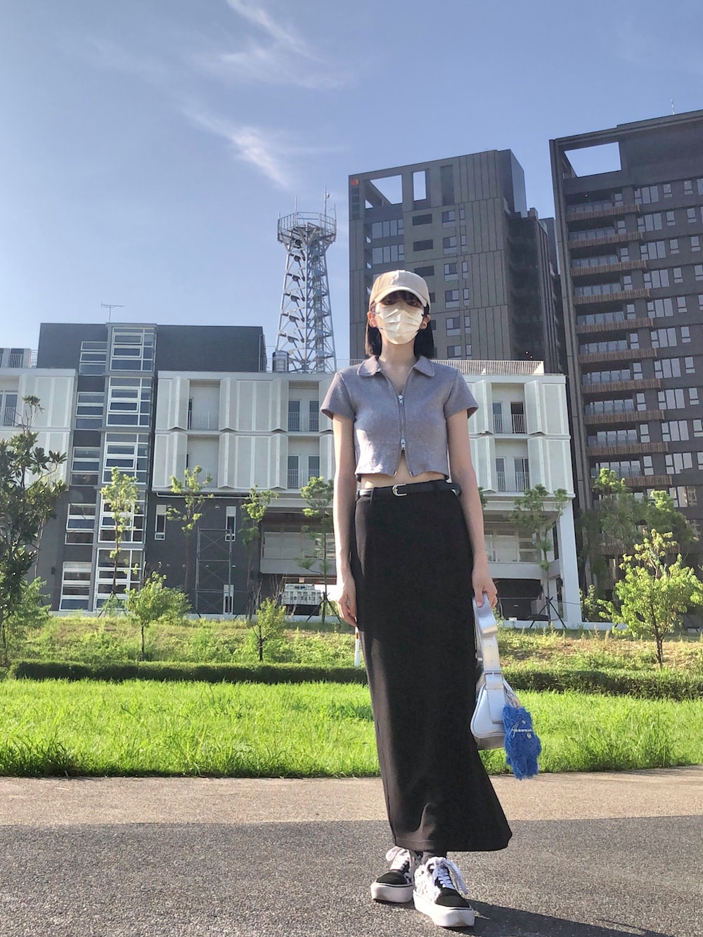 ブラック系のスニーカー、グレー系のポロシャツ、ブラック系のスカートを着用したレディースの夏コーディネートの2枚目の写真