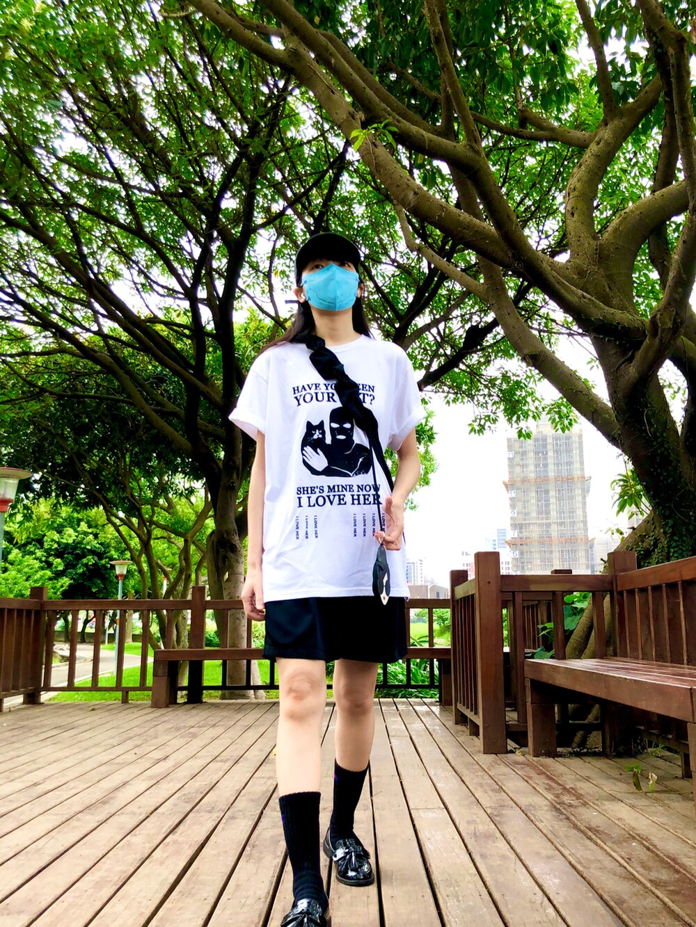 ホワイト系のTシャツ/カットソー、ブラック系のカーゴパンツ、ブラック系のバッグを着用したレディースの春コーディネートの3枚目の写真