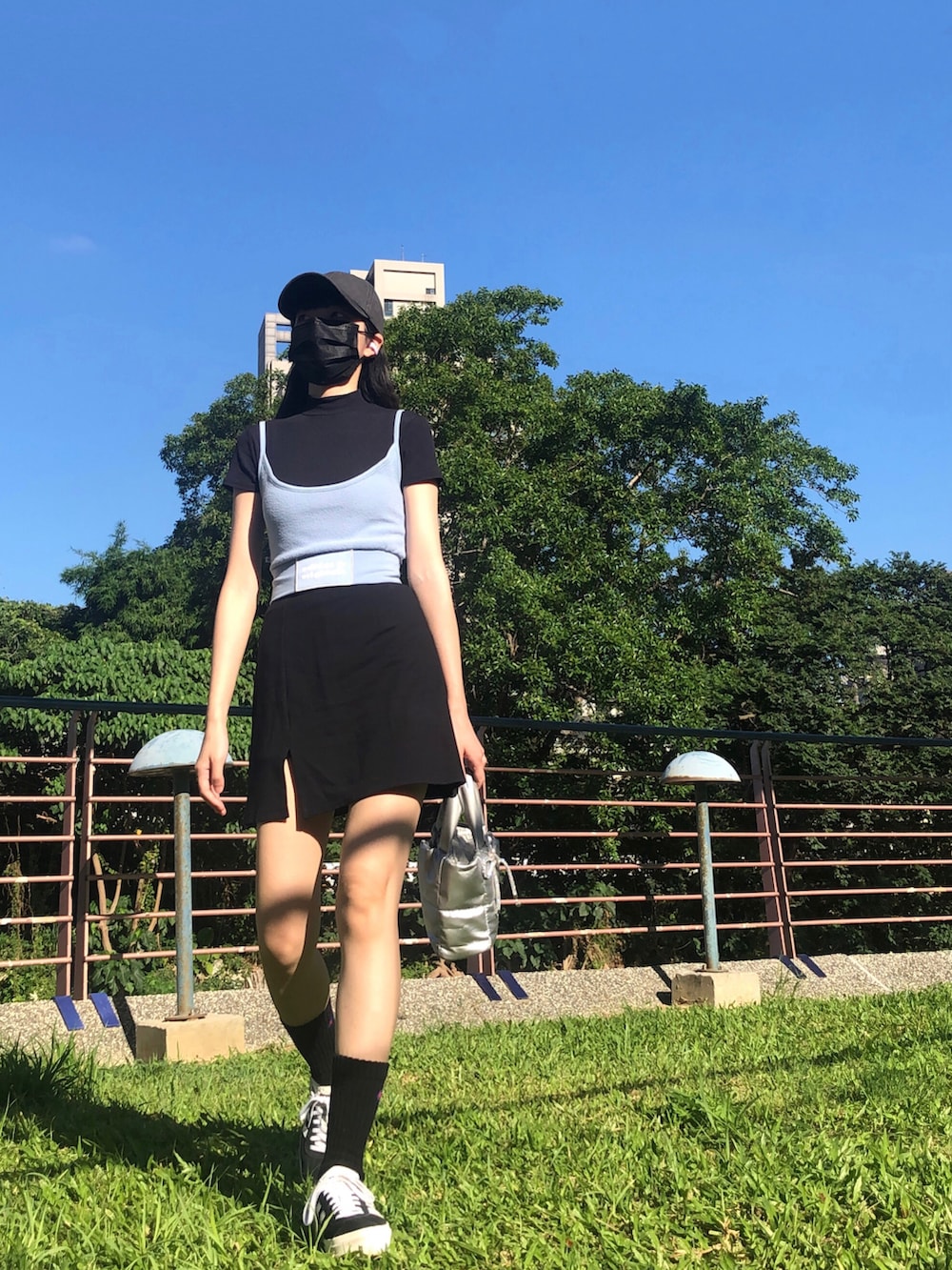 ブラック系のスニーカー、ブルー系のキャミソール、ブラック系のスカートを着用したレディースの夏コーディネートの2枚目の写真