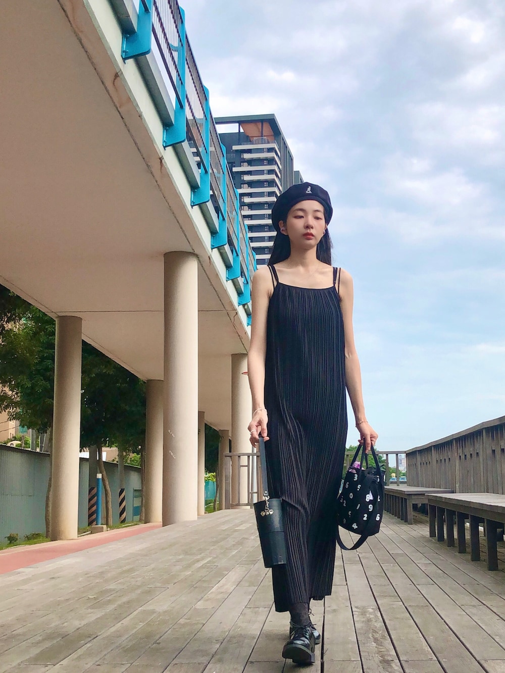 ブラック系のジャンパースカート、ブラック系のバッグ、ブラック系のハンチング/ベレー帽を着用したレディースの夏コーディネートの3枚目の写真