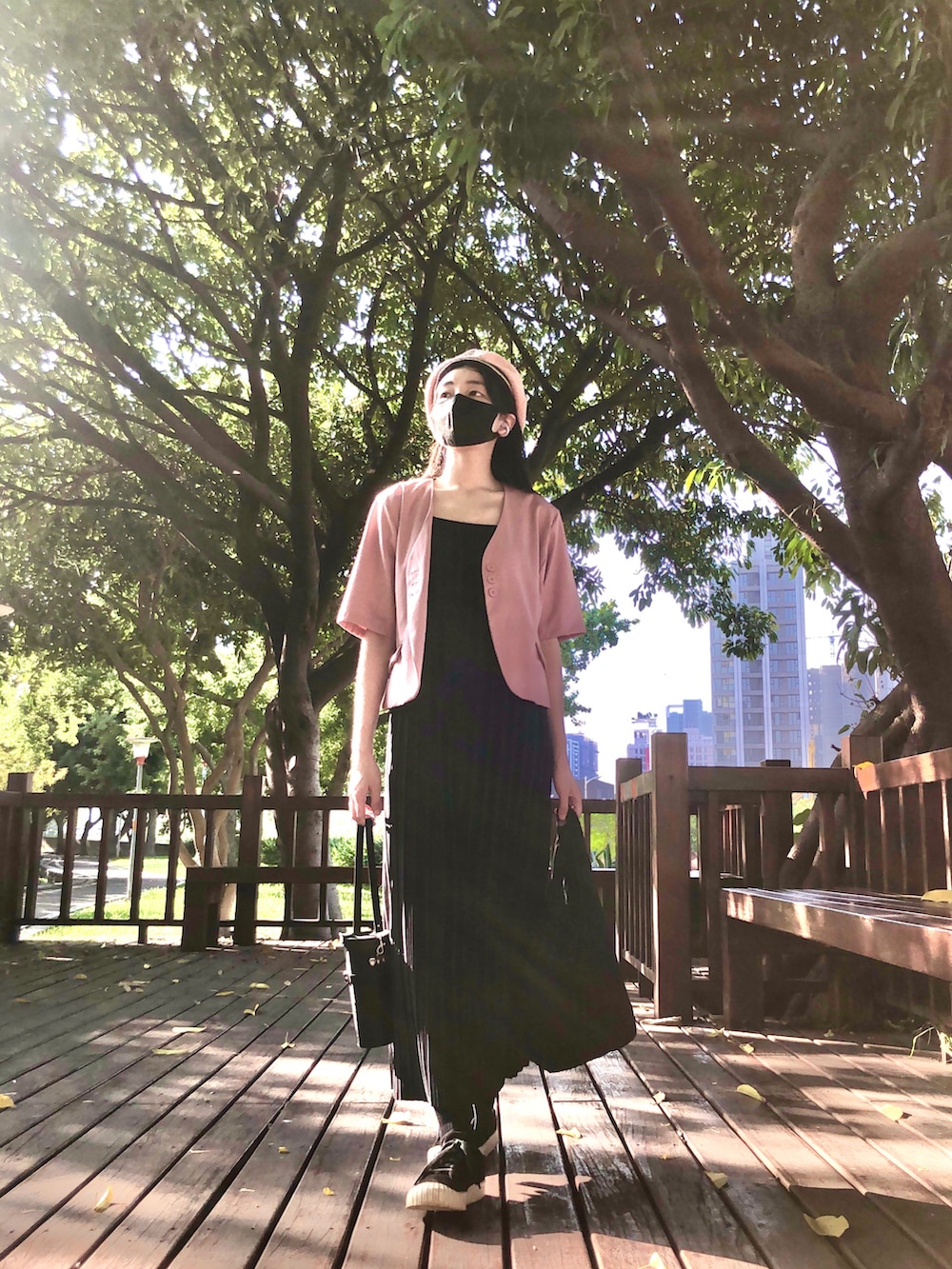 ブラック系のスニーカー、ブラック系のジャンパースカート、ピンク系のスーツジャケットを着用したレディースの秋コーディネートの4枚目の写真