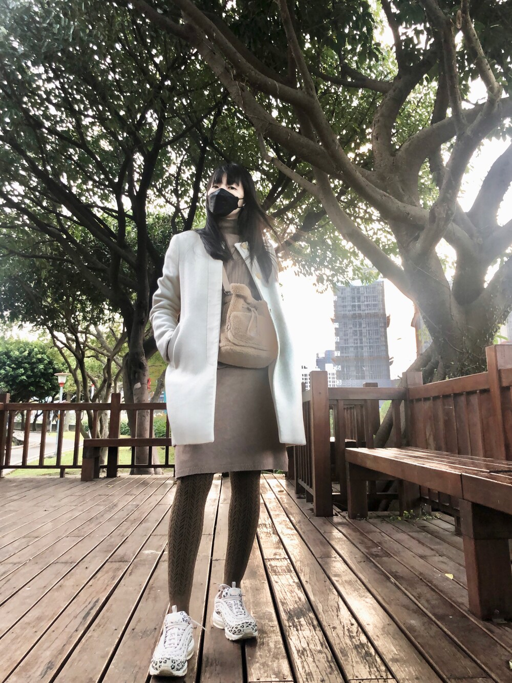 ブラウン系のワンピース/ドレス、ブラウン系のドラムバッグ、ベージュ系のスニーカーを着用したレディースの冬コーディネートの2枚目の写真