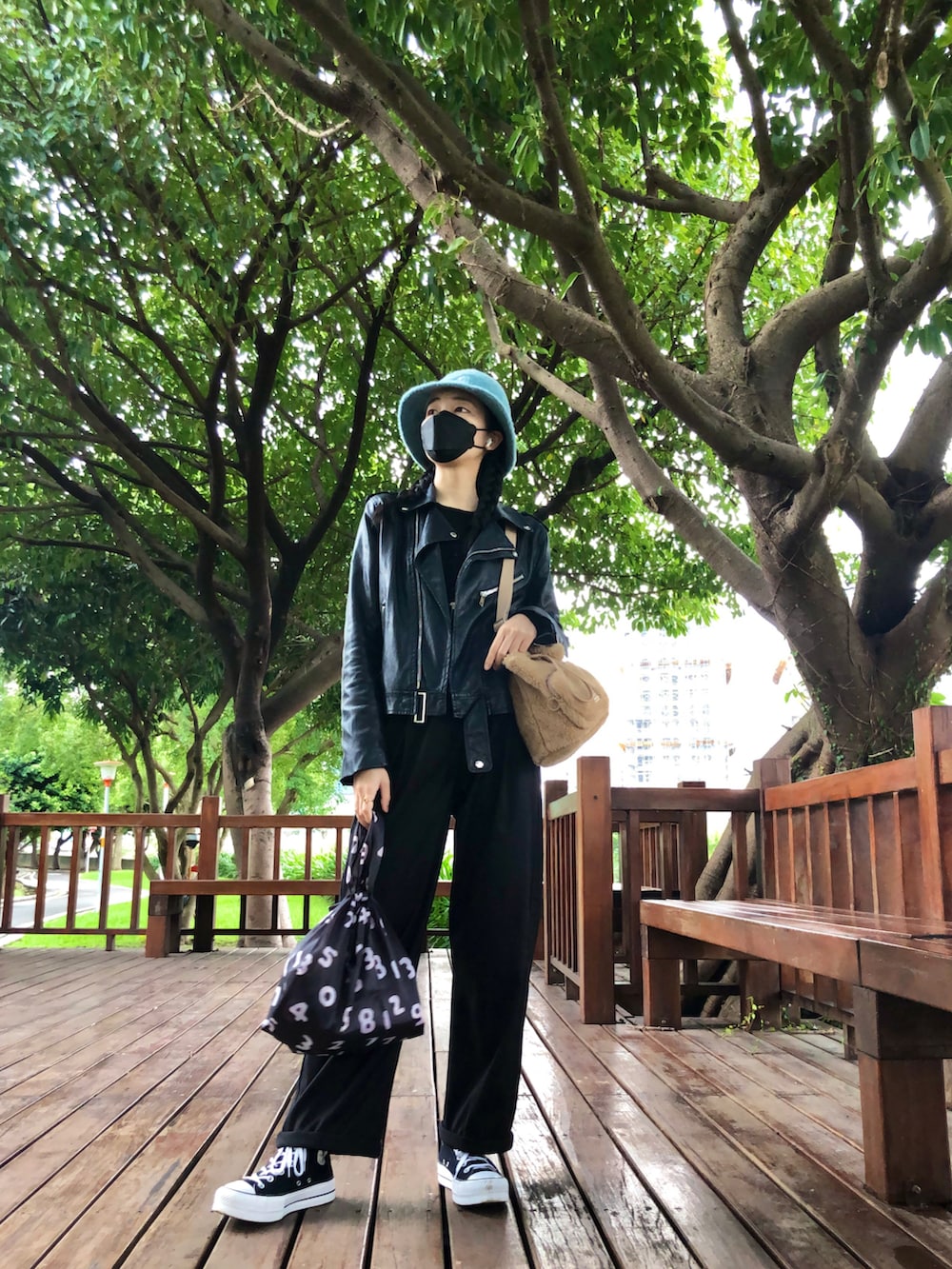 ブラウン系のドラムバッグ、ブラック系のバッグ、ブラック系のスーツパンツを着用したレディースの冬コーディネートの2枚目の写真