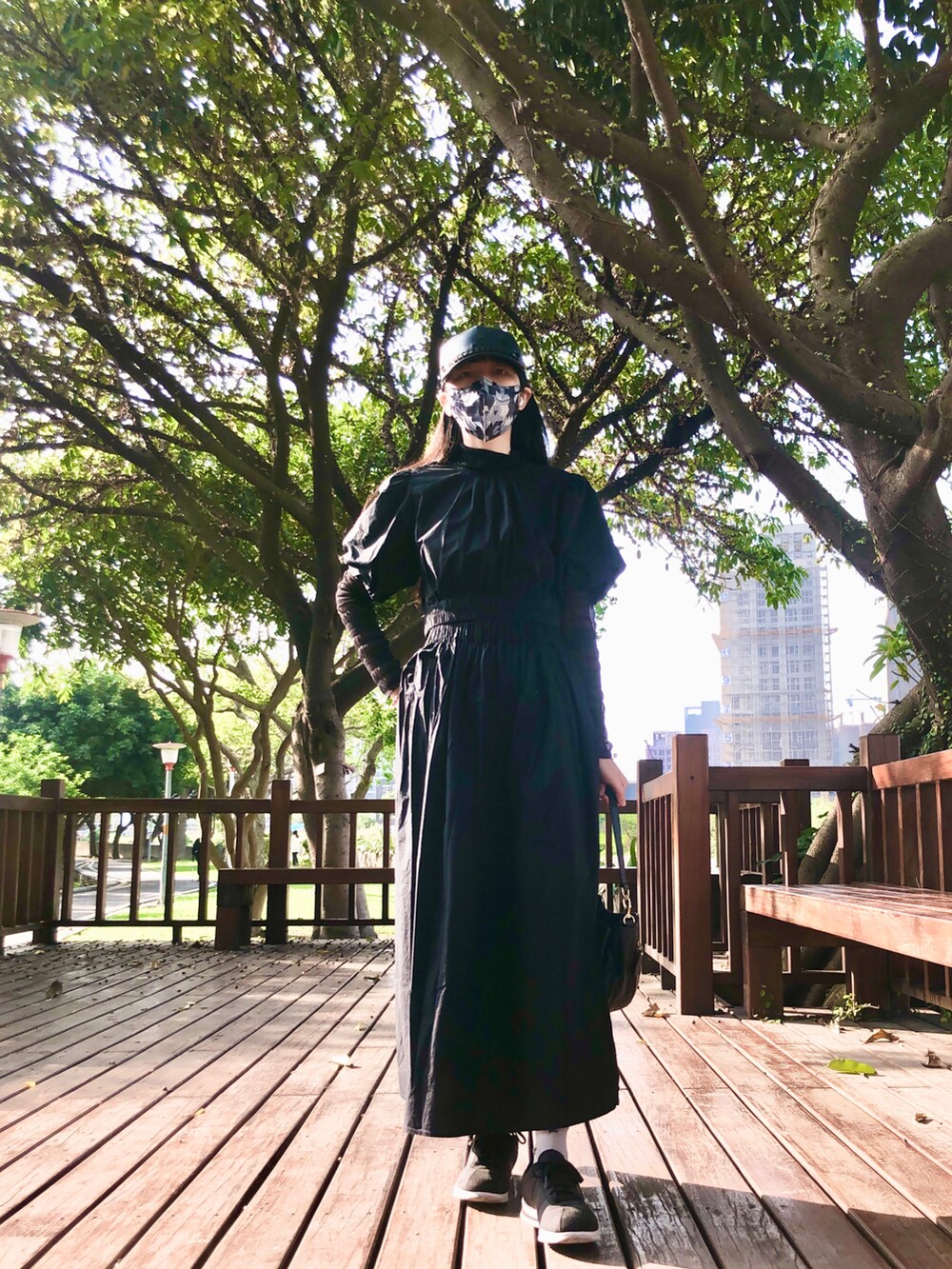 ブラック系のトップス、ブラック系のスカート、ブラック系のシューズを着用したレディースの春コーディネートの4枚目の写真