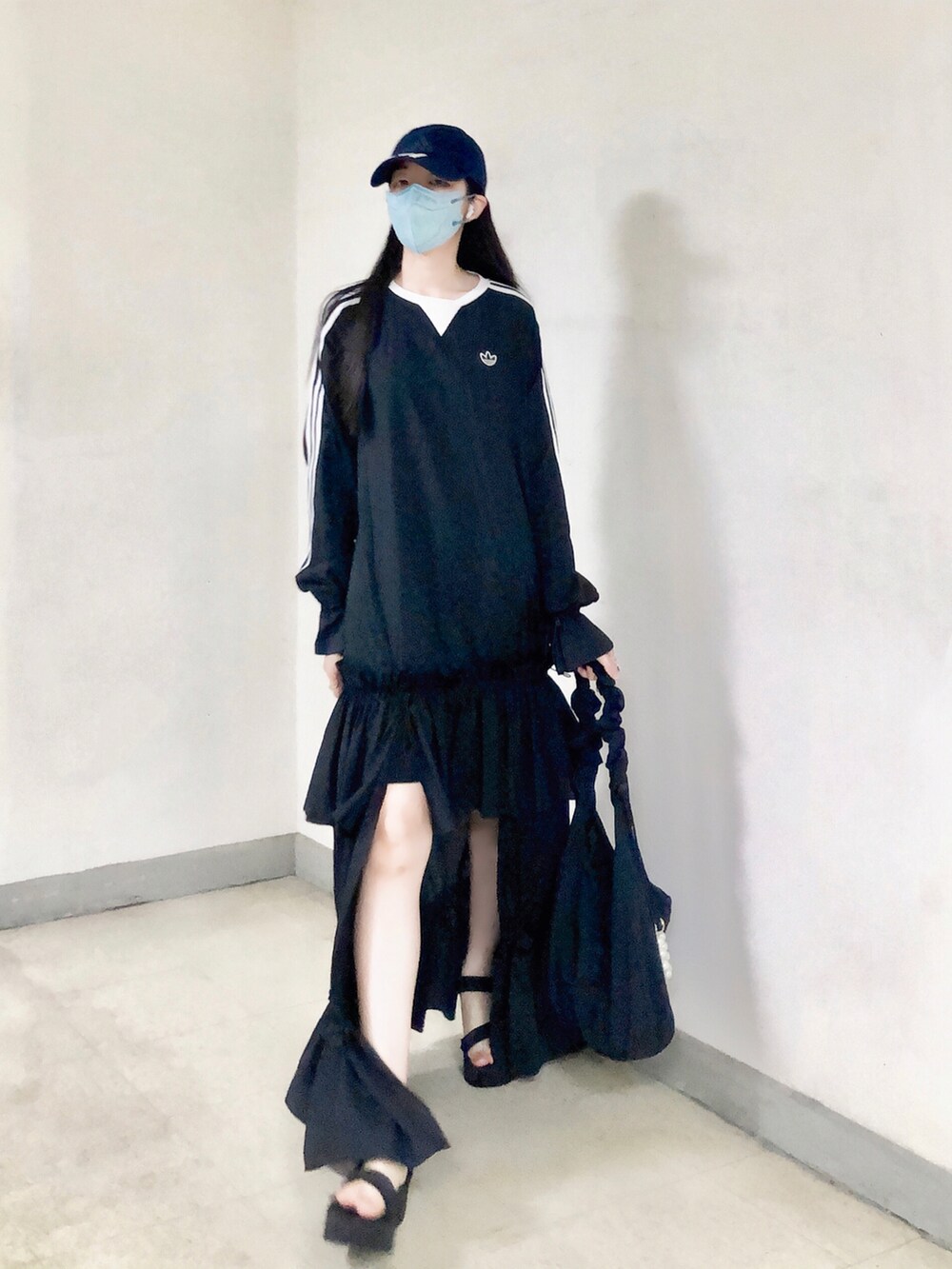 ブラック系のワンピース、ブラック系のバッグ、ブラック系のサンダルを着用したレディースの夏コーディネートの5枚目の写真