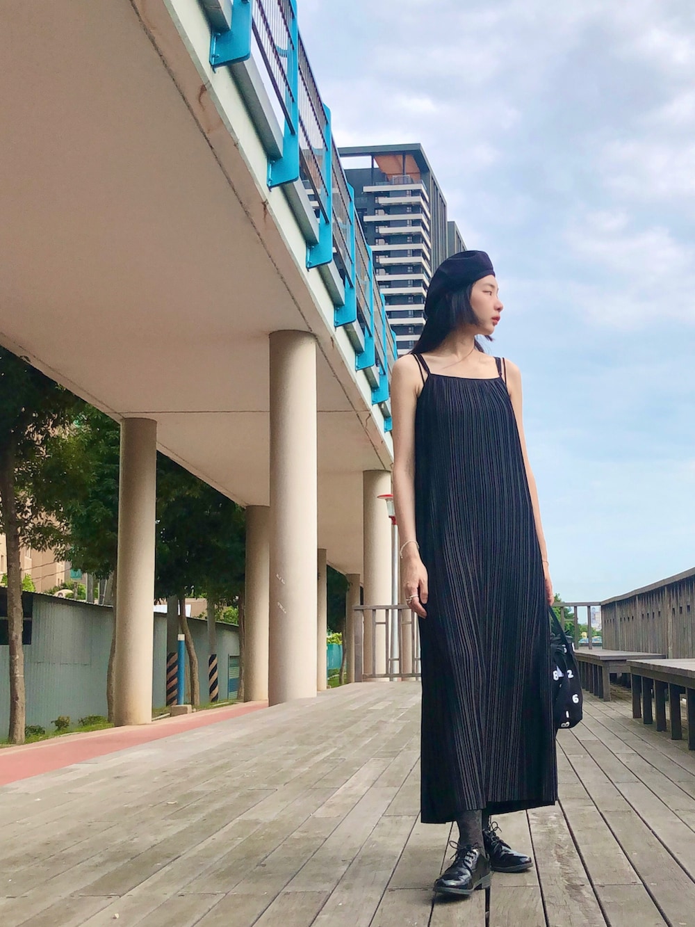 ブラック系のジャンパースカート、ブラック系のバッグ、ブラック系のハンチング/ベレー帽を着用したレディースの夏コーディネートの2枚目の写真