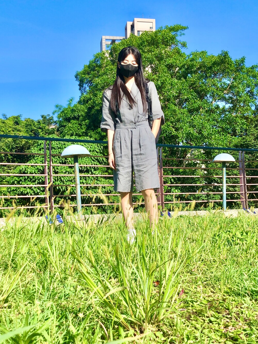 グレー系のスーツセット、ブラック系のバッグ、ホワイト系のスポーツブラを着用したレディースの夏コーディネートの3枚目の写真