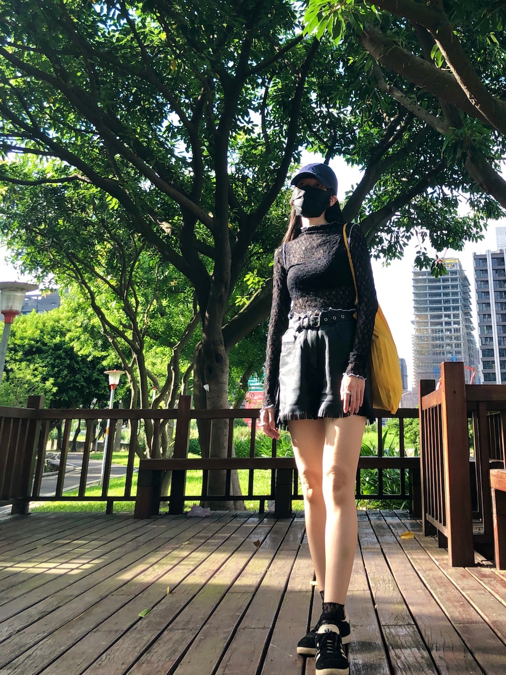 ブラック系のスニーカー、ブラック系のトップス、ブラック系のキャミソールを着用したレディースの夏コーディネートの4枚目の写真