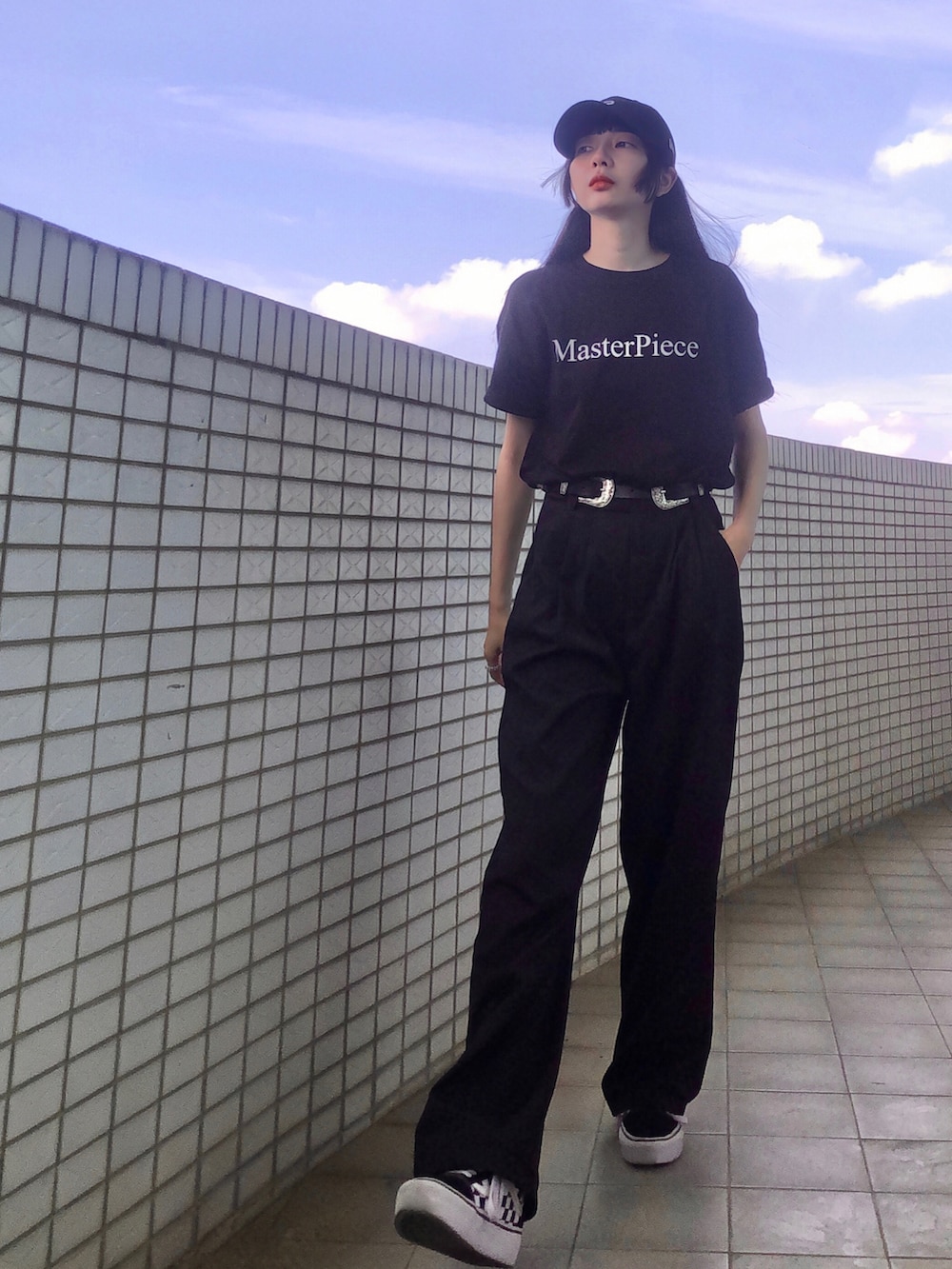 ブラック系のTシャツ/カットソー、ブラック系のスーツパンツ、ブラック系のスニーカーを着用したレディースの夏コーディネートの4枚目の写真