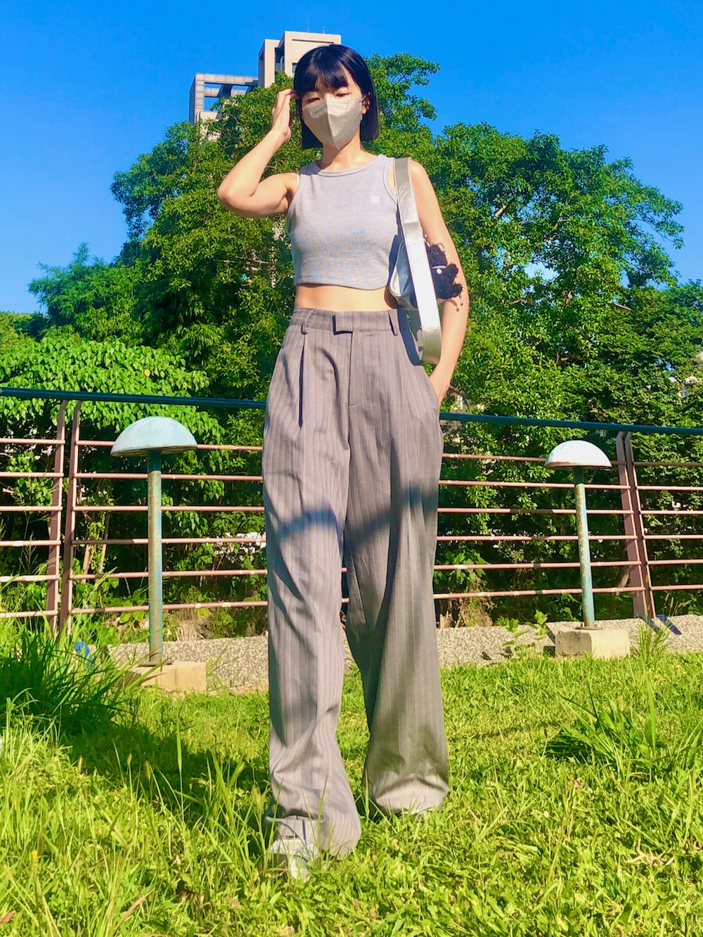 その他のその他トップス、グレー系のスーツパンツ、その他のショルダーバッグを着用したレディースの夏コーディネートの2枚目の写真