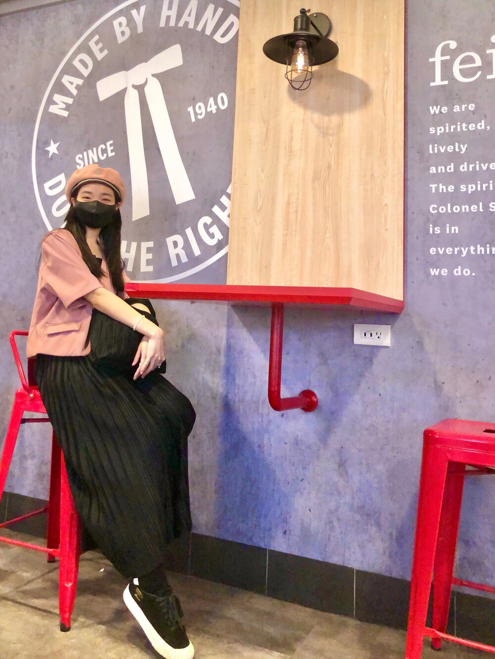 ブラック系のスニーカー、ブラック系のジャンパースカート、ピンク系のスーツジャケットを着用したレディースの秋コーディネートの3枚目の写真