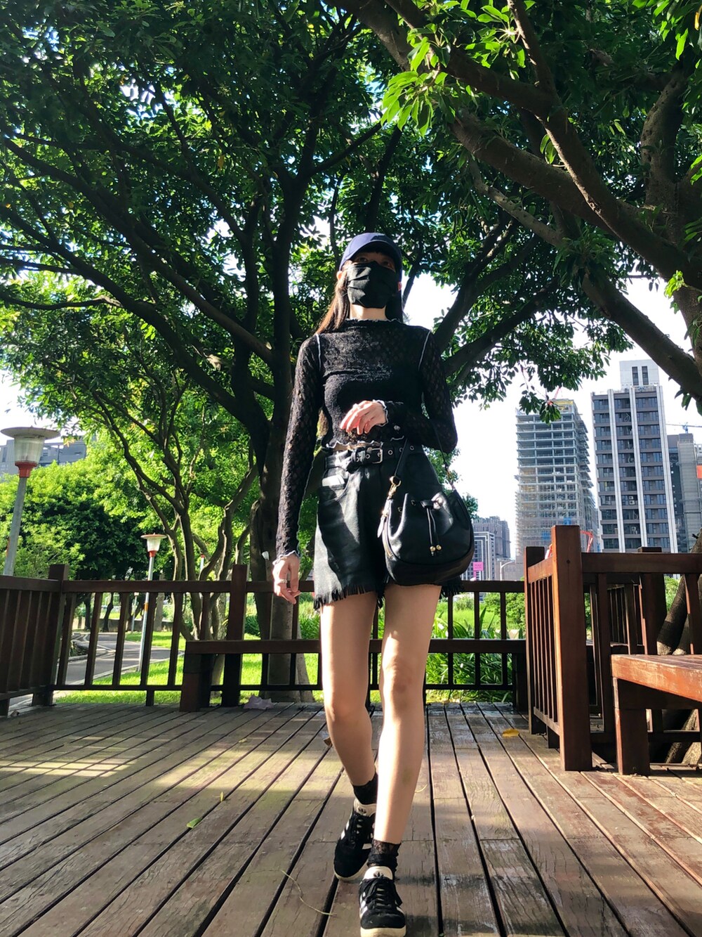 ブラック系のスニーカー、ブラック系のトップス、ブラック系のキャミソールを着用したレディースの夏コーディネートの3枚目の写真