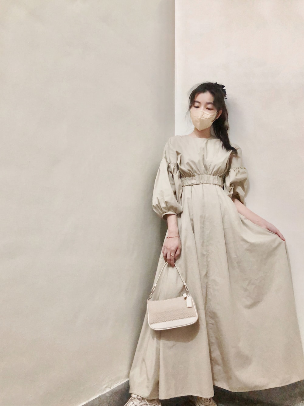 ベージュ系のワンピース、ベージュ系のスニーカー、レッド系のリングを着用したレディースの秋コーディネートの2枚目の写真